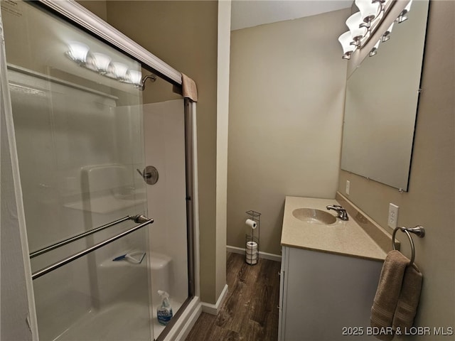 bathroom featuring vanity, hardwood / wood-style flooring, and a shower with door