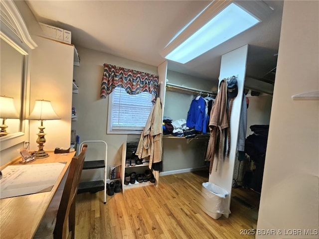 walk in closet with light hardwood / wood-style floors