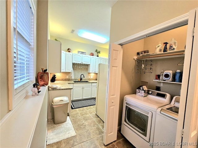 washroom with separate washer and dryer and sink