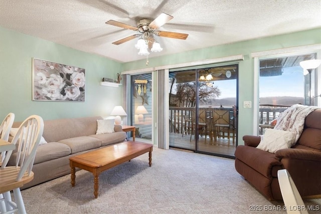 carpeted living room with ceiling fan, a textured ceiling, and a healthy amount of sunlight