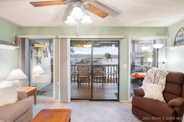 doorway to outside with ceiling fan, light colored carpet, and a textured ceiling