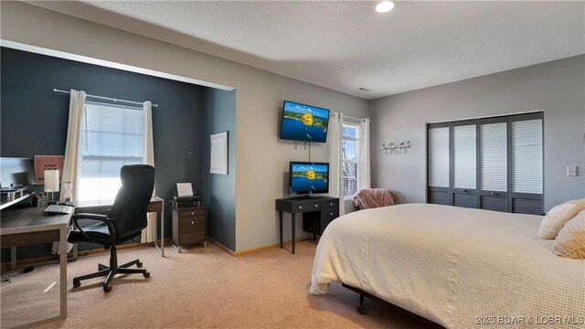 bedroom with light colored carpet and a textured ceiling