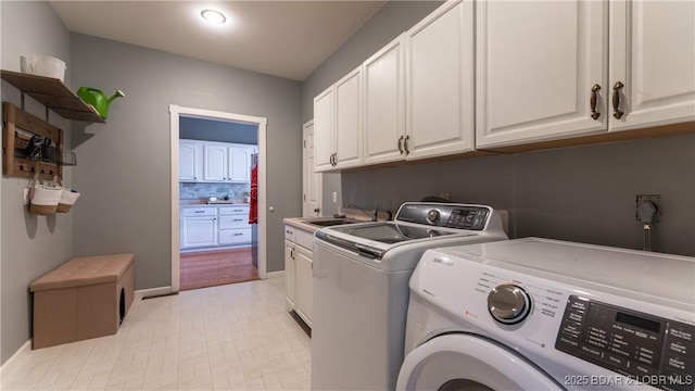 laundry room featuring sink, washer and clothes dryer, and cabinets