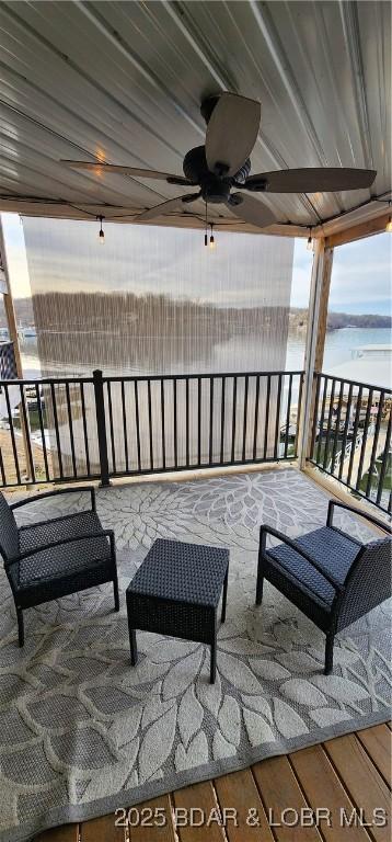 view of patio / terrace featuring a balcony, a water view, and ceiling fan