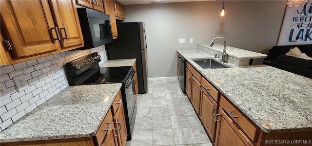 kitchen featuring pendant lighting, sink, light stone counters, tasteful backsplash, and black appliances