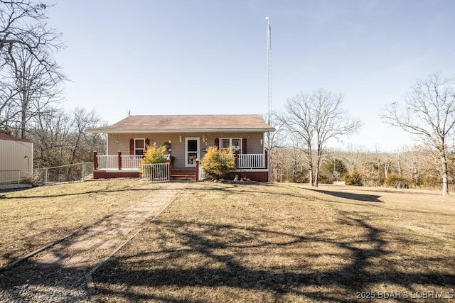 view of front of house featuring covered porch and a front lawn