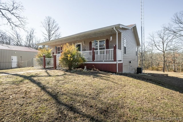 view of front of house featuring central AC, covered porch, and a front lawn