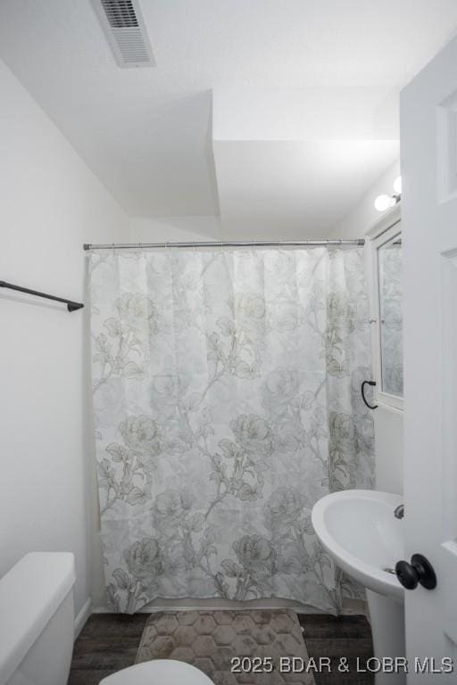 bathroom with a shower with curtain and toilet