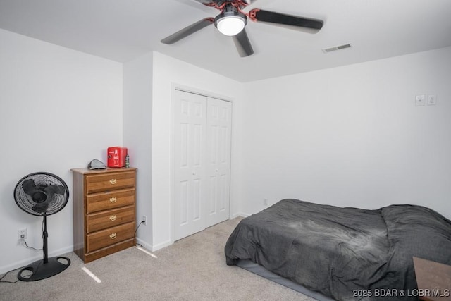 bedroom featuring light colored carpet, a closet, and ceiling fan