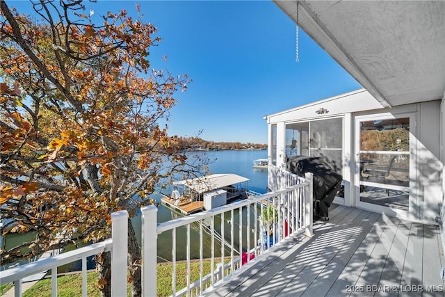 deck with a water view, area for grilling, and a boat dock