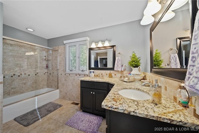 bathroom featuring tile patterned floors, vanity, and bath / shower combo with glass door