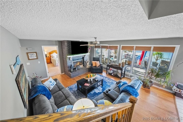 living room featuring hardwood / wood-style flooring, a fireplace, a textured ceiling, and a wealth of natural light