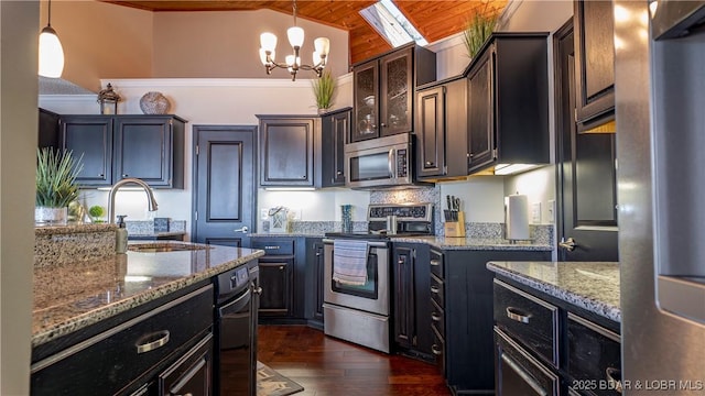 kitchen with sink, appliances with stainless steel finishes, dark brown cabinets, light stone counters, and decorative light fixtures