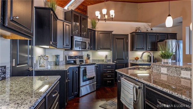 kitchen featuring dark brown cabinetry, sink, dark hardwood / wood-style floors, pendant lighting, and stainless steel appliances