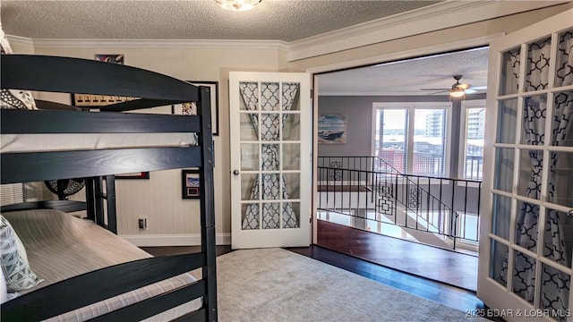 bedroom with hardwood / wood-style flooring, ornamental molding, a textured ceiling, and french doors