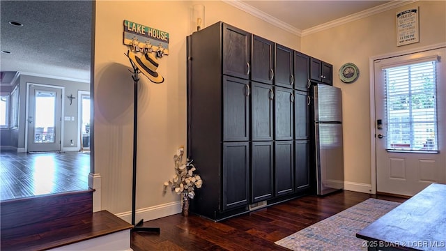 entrance foyer featuring crown molding, a textured ceiling, and dark hardwood / wood-style flooring