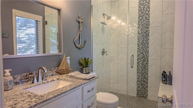 bathroom with vanity, toilet, and a shower with shower door