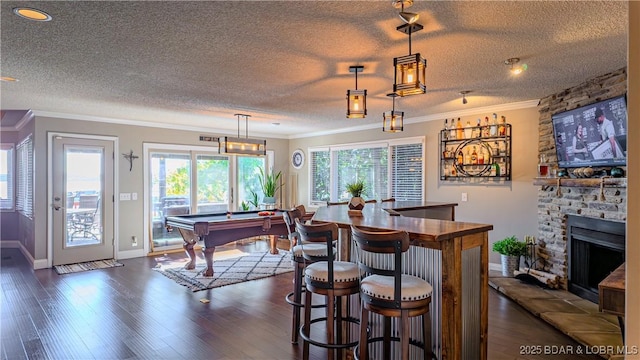 bar with ornamental molding, pendant lighting, and dark hardwood / wood-style flooring