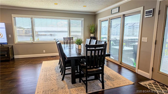 dining space featuring dark wood-type flooring, crown molding, and a textured ceiling