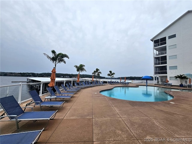 community pool with a water view and a patio area