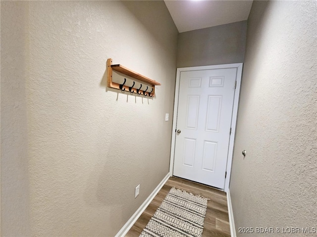 doorway with baseboards and wood finished floors