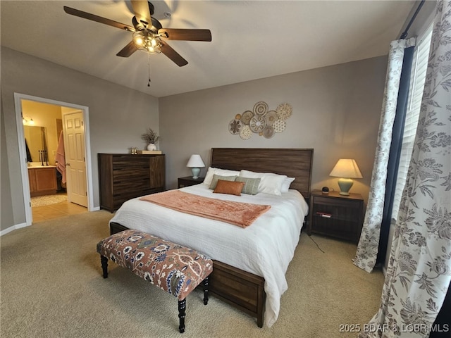 bedroom featuring ensuite bathroom, light carpet, and ceiling fan