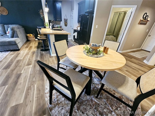 dining area with sink and light hardwood / wood-style floors