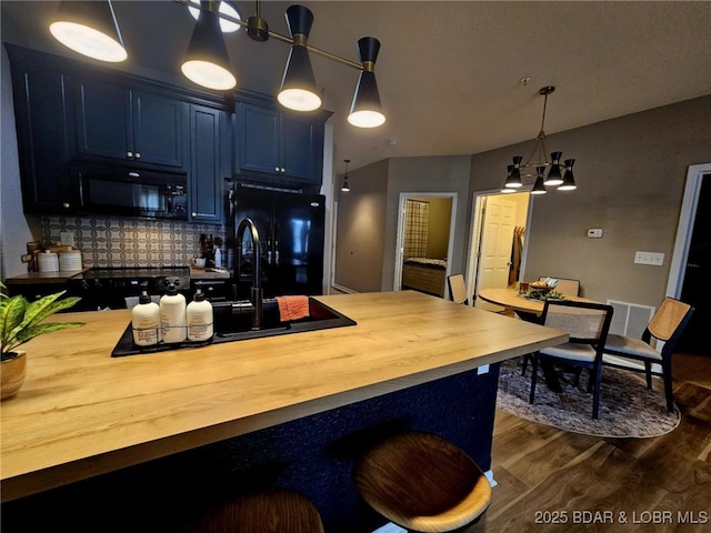 kitchen featuring dark wood-style flooring, butcher block countertops, tasteful backsplash, black appliances, and blue cabinets