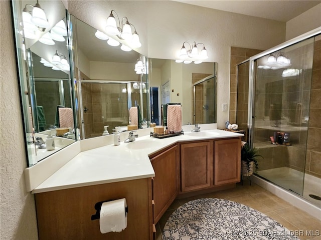 full bath featuring double vanity, a sink, tile patterned flooring, and a stall shower