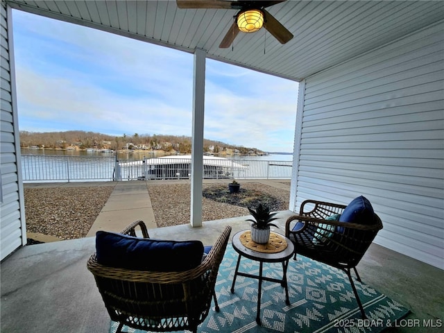 view of patio with a water view and ceiling fan