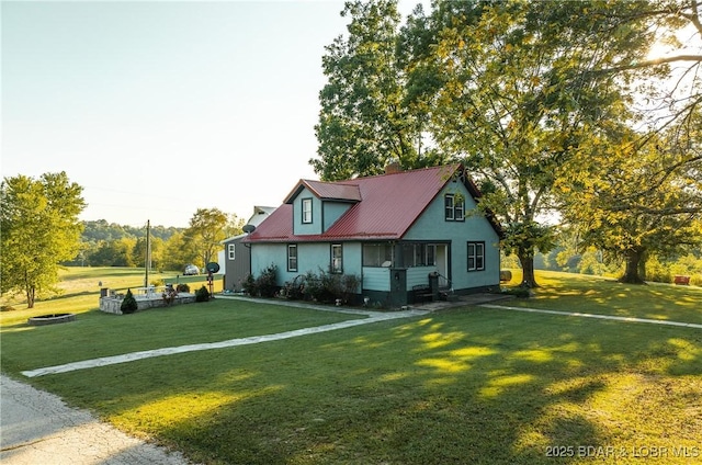 cape cod home featuring a front lawn