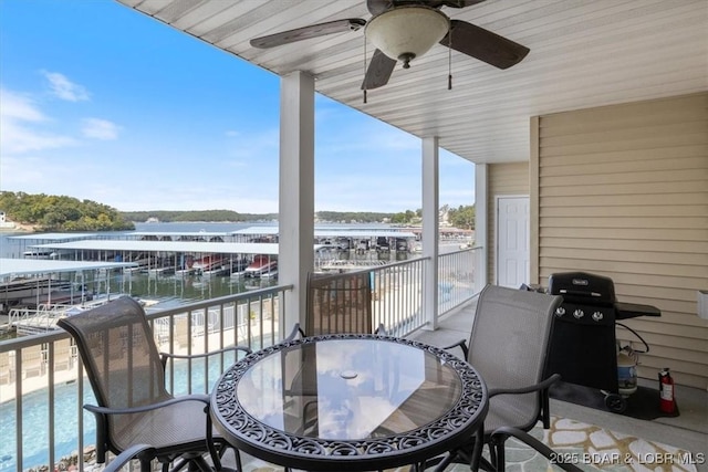 balcony featuring a ceiling fan, a water view, outdoor dining space, and view of pool