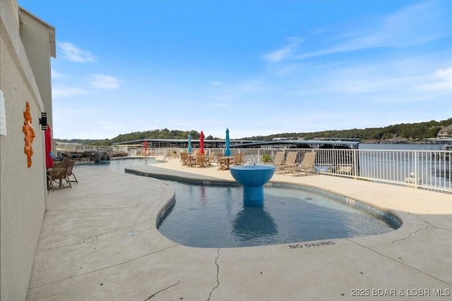 view of pool featuring a water view and a patio