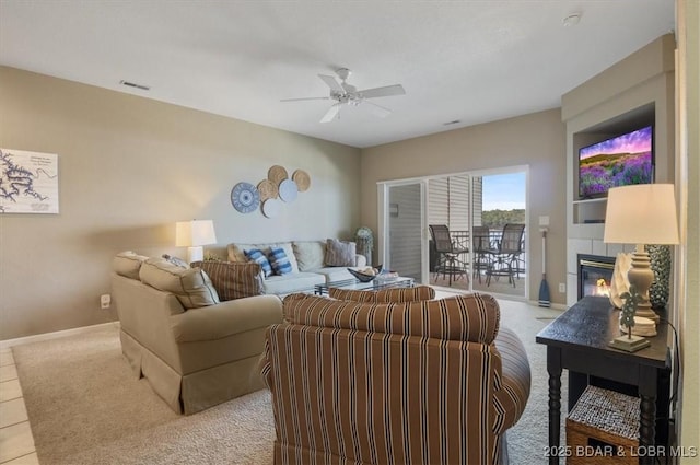 living room with ceiling fan and a tile fireplace