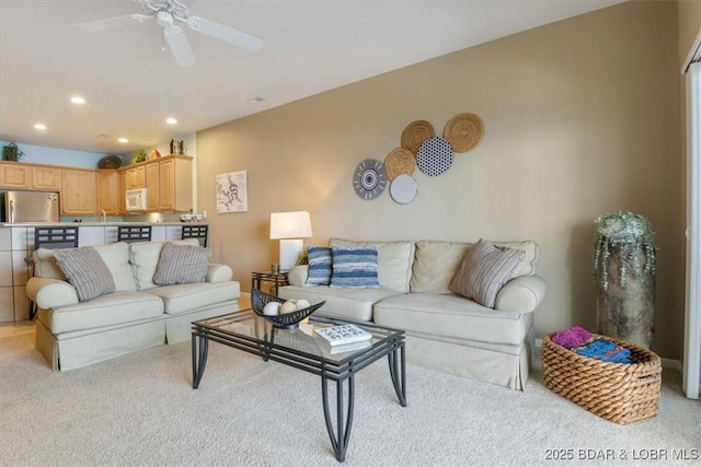 living room with ceiling fan, sink, and light carpet