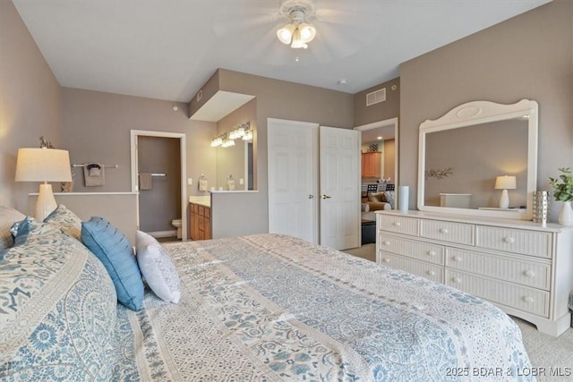 carpeted bedroom with connected bathroom and ceiling fan