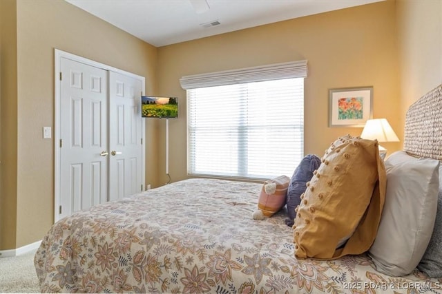 carpeted bedroom with a closet and ceiling fan