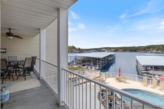 balcony with a water view and ceiling fan