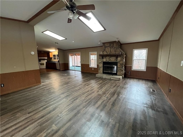 unfurnished living room featuring dark hardwood / wood-style flooring, plenty of natural light, ornamental molding, and vaulted ceiling