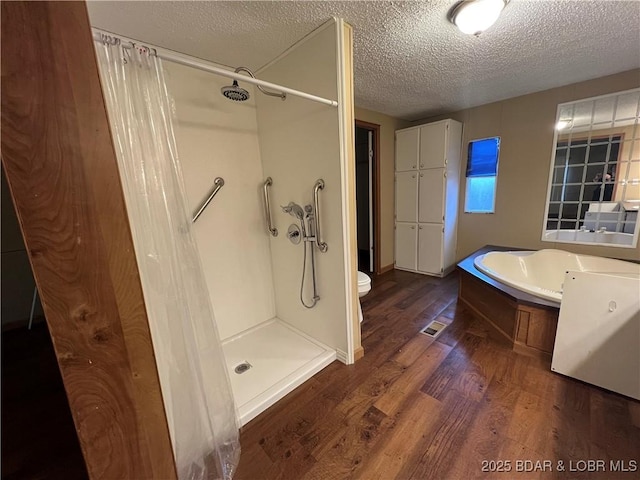 bathroom with toilet, plus walk in shower, hardwood / wood-style floors, and a textured ceiling