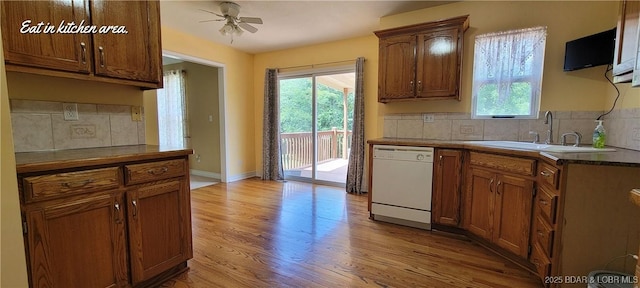 kitchen with sink, light hardwood / wood-style flooring, dishwasher, ceiling fan, and backsplash