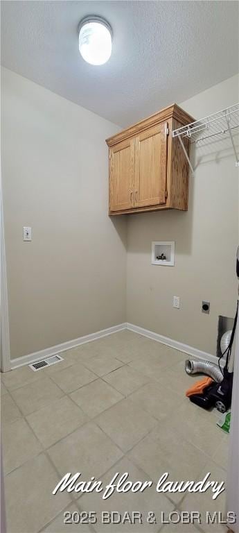 laundry area featuring cabinets, hookup for a washing machine, hookup for an electric dryer, and a textured ceiling