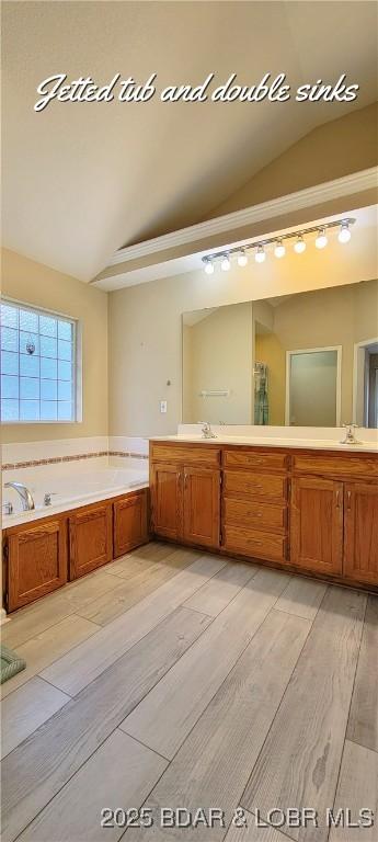 bathroom featuring a tub, lofted ceiling, wood-type flooring, and vanity