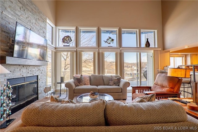 living room with a fireplace and a towering ceiling