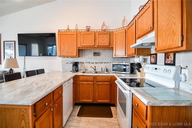 788 Kersten Way Unit A308, Osage Beach, MO 65065 - kitchen with white appliances, under cabinet range hood, a sink, a peninsula, and light countertops