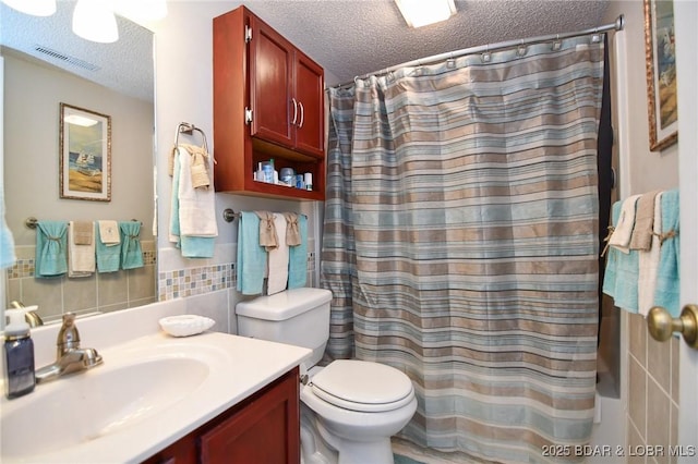 bathroom featuring a shower with curtain, vanity, a textured ceiling, and tile walls