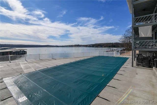 view of pool featuring a patio area and a water view