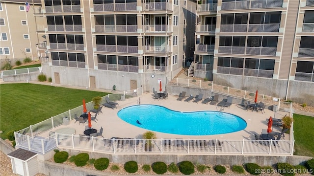 view of pool with a patio and a lawn