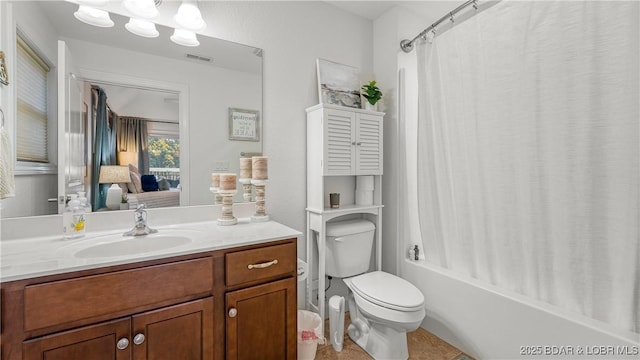 full bathroom with vanity, shower / bath combo, and toilet