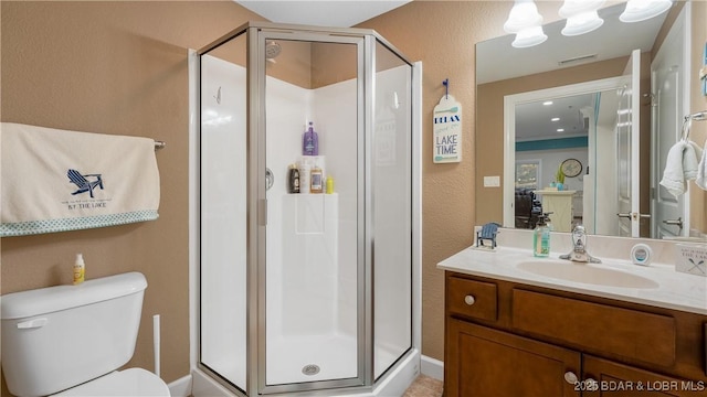 bathroom featuring vanity, toilet, and a shower with door